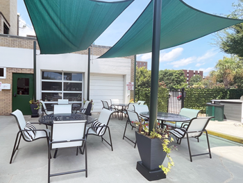 a patio with a table and chairs and a grill